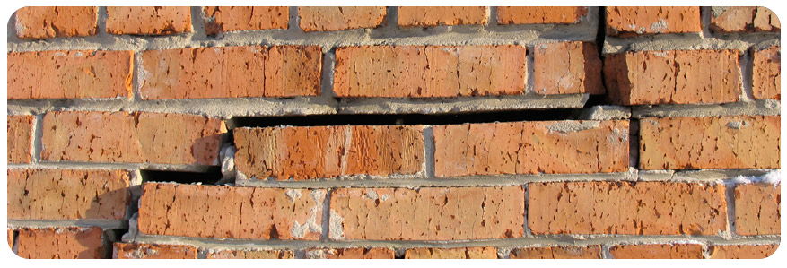 a red brick wall with a crack in it
